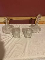 Four pieces on table including two crystal decanters and two rectangular glass holders