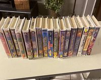 Front view of 18 vintage Disney VHS tapes lined up, showing colorful spine art and titles.