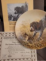 Collector plate showing German Shorthaired Pointer puppies with certificate and original packaging titled 'Fritz's Folly'