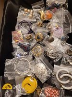 Photo of assorted packaged earrings in various styles including hoops, studs, metallic embossed, and colorful enamel pieces.