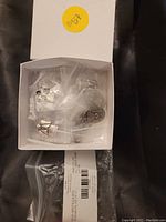 Box containing individually bagged pewter angel and affirmation tokens along with the box lid.