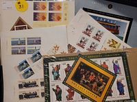 Multiple sheets of assorted stamps including a large Marshall Islands Last Supper sheet, Canada Historic Public Service Vehicles stamps, and other Canadian stamps with transportation and lighthouse themes.