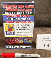 Front view of the sealed 2007 NHL Gems of the Game Series 2 box with bold purple, red, and yellow design showing key vintage packs possible to find including 1985/1986 Topps.