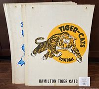 Grouped photo showing six 1960s CFL team broadsides including Hamilton Tiger-Cats on top.