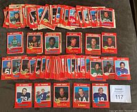 Set of 1971 CFL football cards, mostly laid out in stacks and some cards shown individually including Joe Theismann rookie card, featuring red borders and player images with team logos on cards.