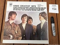 Front cover of the 1971 Kinks Greatest Hits album showing the band members and featured hit songs.
