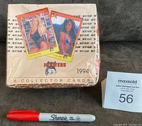 Front view of the sealed 1994 Hooters trading card wax box with two card samples shown on top and a red Sharpie marker for size reference.