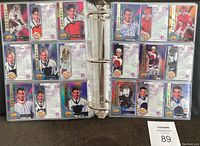Binder pages displaying multiple 1994 Signature Rookies hockey cards, each card in protective sleeves showing front player images and biographical text on back.