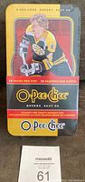 Front top-down photo of sealed 2007-08 O-Pee-Chee hockey card tin featuring Bobby Orr and branding.
