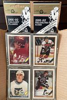Box of 24 sealed 1991-92 O.P.C. hockey card team packs and some displayed cards in protective sleeves showing player portraits.