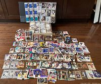 Full spread of approximately 3,000 hockey cards laid out on floor including the Pinnacle set in binder pages and multiple star player cards