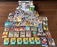 Full lot of hockey cards and memorabilia laid out on floor showing cards, boxes, and wax packs