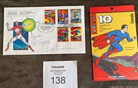 First Day Cover with 5 stamps and Les Barker signatures, next to booklet of 10 superhero stamps
