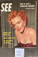 Front cover of July 1952 SEE magazine featuring Marilyn Monroe with red hair, posing in a strapless dress with earrings, headline articles visible