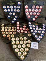 All six Original 6 NHL team shields arranged on a surface, each shield displaying circular player coins with portraits from the 1966-67 season. The coins are arranged in team-specific color schemes.