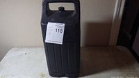 Black plastic Coleman lantern carrying case with handle and lid closed.