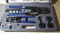 Open case showing Zurn crimp tool with blue handles, three jaws, crimp removal tool, and metal gage laid out in fitted compartments