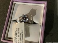 Ring presented in pink jewelry box with visible tag