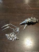 Full view of metal steampunk style full finger claw ring with chains and skull ornamentation