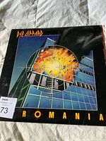 Front cover of Def Leppard Pyromania vinyl LP showing colorful explosion and target design on building.