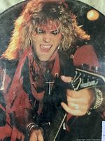 Close-up image of one side of the Ratt picture disc vinyl showing a blonde band member playing guitar in red stage clothing.
