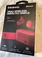 Front view of box showing Skullcandy Truly Wireless earbuds in red, Bluetooth enabled, up to 24 hours battery life with charging case, water resistant and Tile tracking.