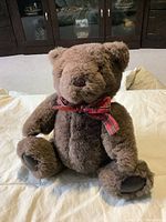 Full body of vintage Gund teddy bear showing brown soft fur and red plaid bow.