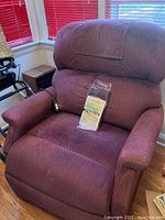 Front view of the maroon fabric electric recliner lift chair with remote on the right armrest, showing cushioned seat and backrest.