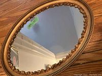 14 x 12 oval vintage mirror with detailed gold ornate frame with floral or leaf motif