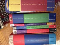 Stack of seven Harry Potter books showing various titles with Bloomsbury and Raincoast publishing on spine.