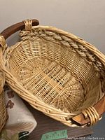 Close-up of large wicker basket showing woven detail and wooden handle.