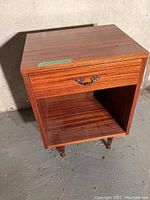 Photo of one wood retro side table, showing drawer and open lower shelf, with vintage legs.
