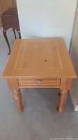 Front view of Broyhill oak end or side table showing drawer and turned legs