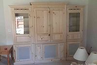 Front view of the entire large entertainment center showing four-piece construction with two glass door cabinets on sides, closed cabinetry in middle and lower screened doors.