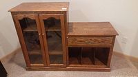 Front view of solid oak entertainment unit showing two glass doors, drawer, and open cubbies.