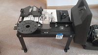 Metal router/jigsaw table with adjustable guide and legs on carpet