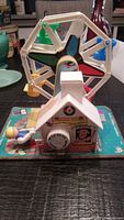 Full view of the Vintage 1964 Fisher Price Ferris Wheel toy showing the wheel with colorful seats and base with toy details.