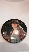 Close up front view of the round Coca-Cola pocket mirror showing woman in vintage attire holding glass of Coca-Cola with text 'At Fountains 5¢'