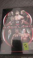 DVD cover showing wrestlers John Cena, Shawn Michaels, Triple H, Vince McMahon, Chris Jericho from WWF wrestling event Backlash.