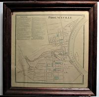 Full view of the framed antique map showing the oak frame and overall map appearance with tan aged paper and details in black ink with some blue highlights.
