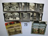 Top view of multiple Keystone real photo stereoviews and other stereoviews laid out showing black and white images of people, streets, mountains, and nature scenes.