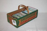 Cardboard basket labeled Greenhouse Tomatoes filled with hundreds of postcards mostly in mint or unused condition.