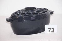 Side view of deep blue cast iron steamer/humidifier with lattice top and handles, showing 3D form and color.