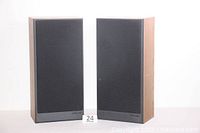Pair of Polk Audio S6 speakers side by side with grilles on, showing wood veneer cabinets and black cloth fronts.