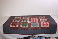 Full view of the folded Churn Dash quilt showing its patchwork pattern and color scheme.