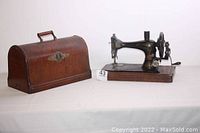 Singer antique hand crank sewing machine and matching bentwood case side by side