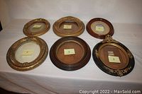 Six numbered oval antique picture frames displayed on white cloth: various wood and gesso with gilt trim and walnut frames.