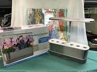Photo of Aerogarden unit alongside original box showing model and branding.