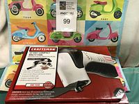 Full view of Craftsman 12 Volt compact multi-tool in box, showing the tool and packaging with product info on front.