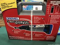 Front side of the closed box of Dremel Lithium-Ion Cordless rotary tool showing branding, features and carrying handle.